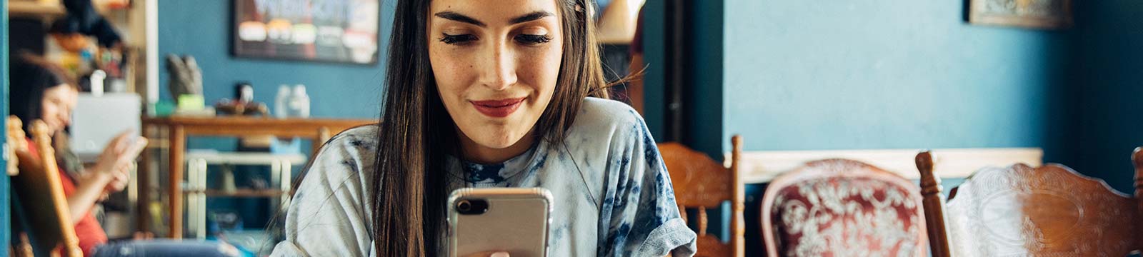 Lady in a cafe using a smartphone