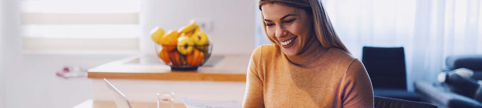 Lady using a laptop computer in her kitchen